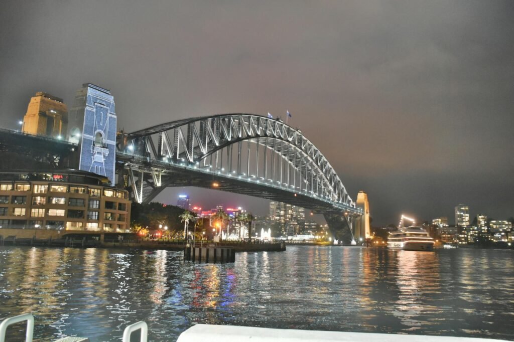 Stunning night view of the illuminated Sydney Harbour Bridge reflecting in the water.
